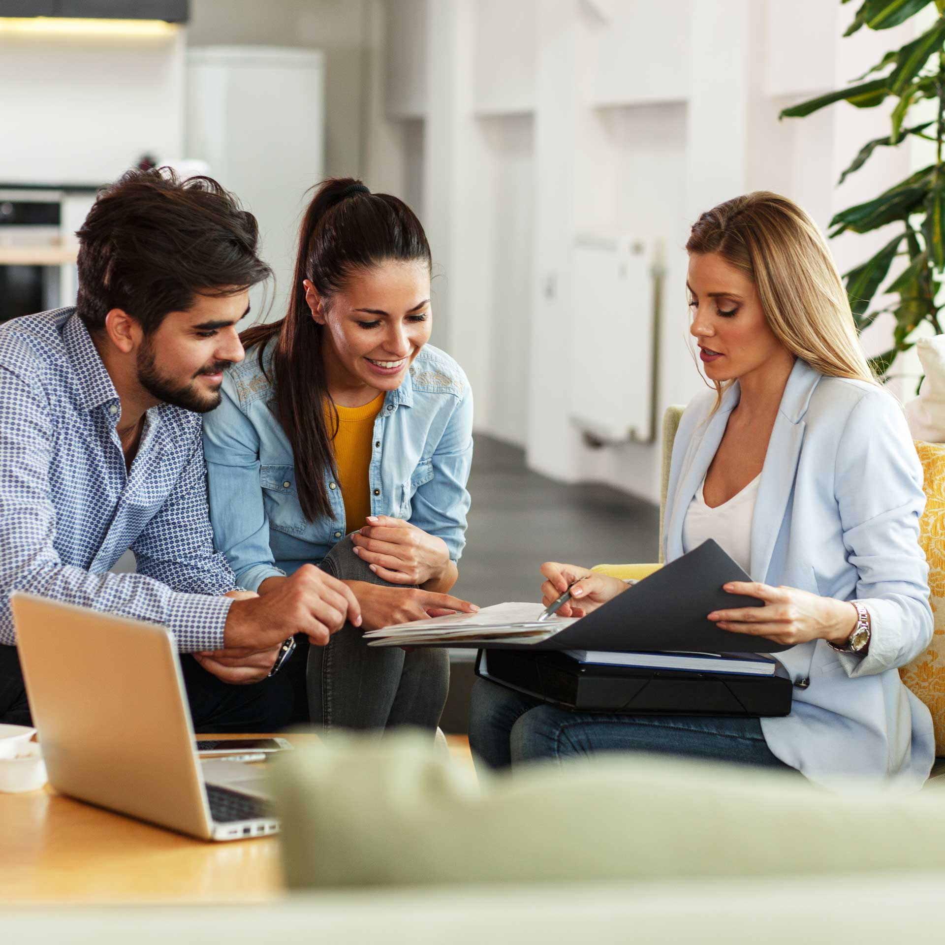 Professionnale de la gestion de patrimoine en rendez-vous client avec un couple de trentenaire